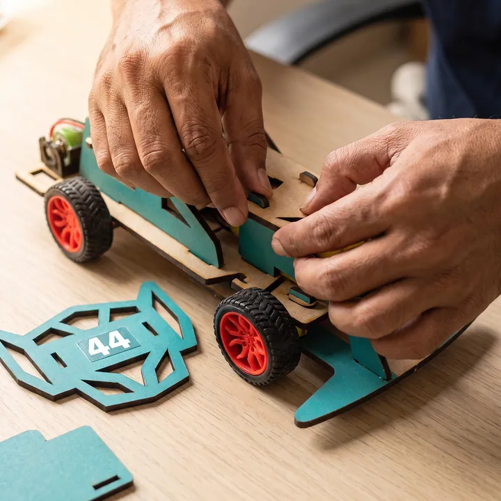 Adult hands pressing a laser-cut wooden tab into place by hand, no tools